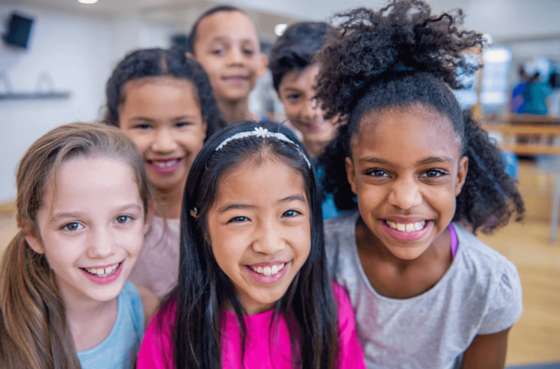 Group of smiling children posing together indoors