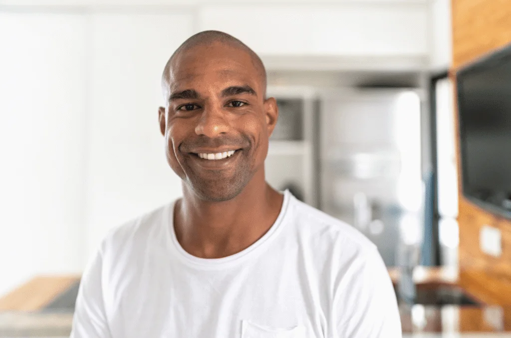 Smiling adult man in a white t-shirt with a bright, straight smile