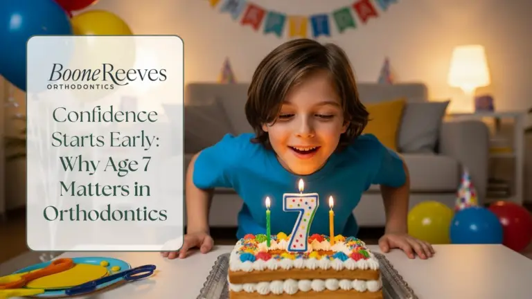 Smiling boy at a birthday party leaning toward a cake with a number 7 candle